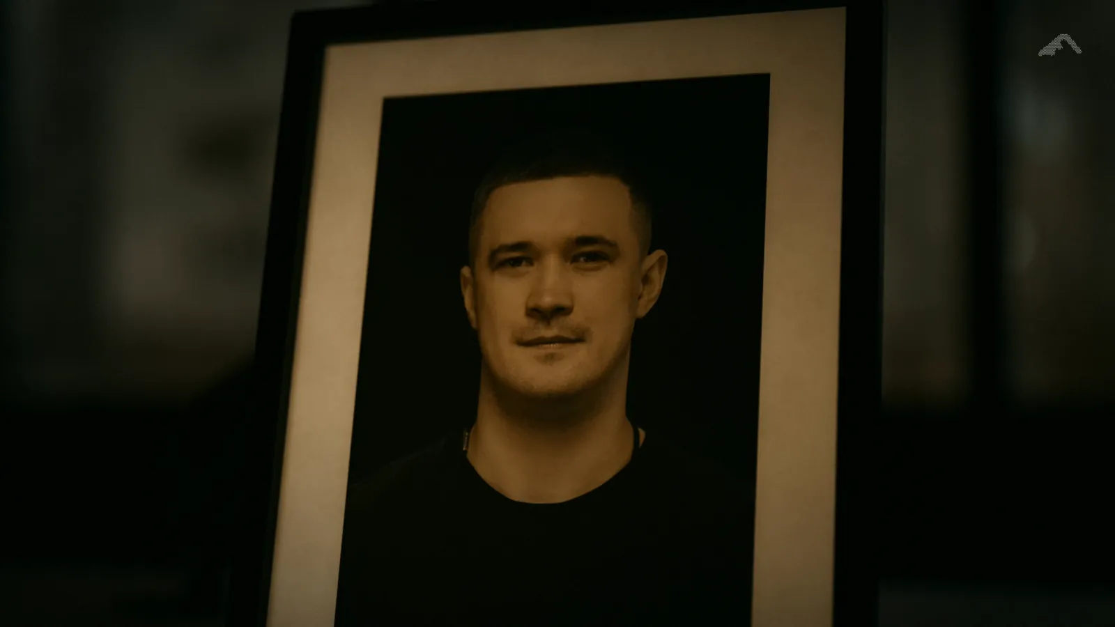 A framed photograph of Mykhailo Fedorov standing on a dark desk.
